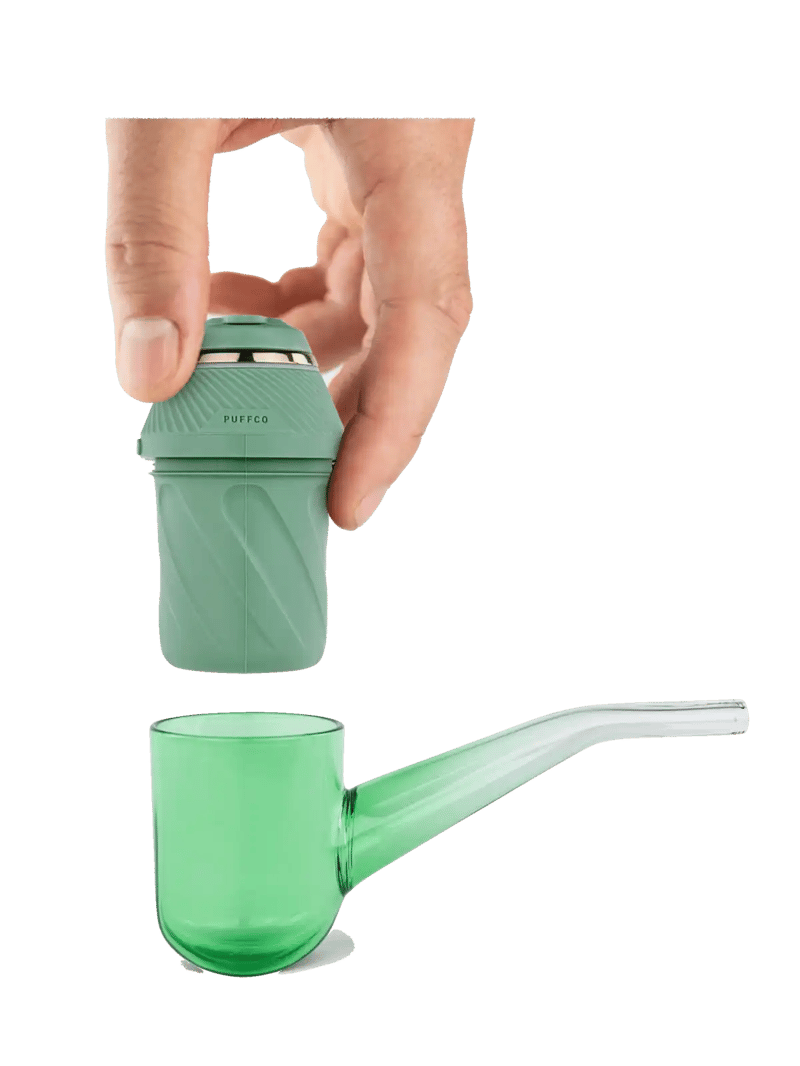 Hand holding a detachable green component above a matching green glass pipe from the Proxy Kit.