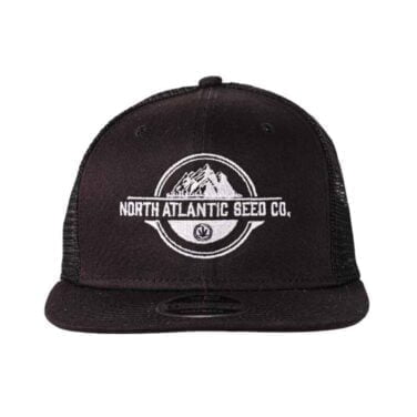 A black trucker hat with a white embroidered logo featuring mountains and the text "North Atlantic Seed Co." on the front.