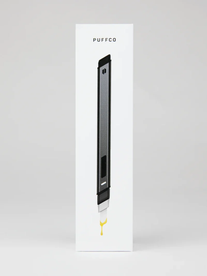 Image of Puffco Hot Knife product packaging showcasing a sleek, pen-like device with a hot knife attachment at the bottom, photographed against a plain white background.