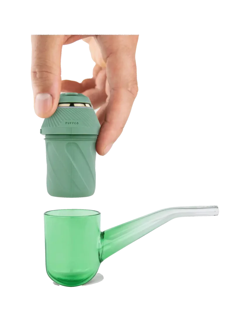 Hand holding a detachable green component above a matching green glass pipe from the Proxy Kit.